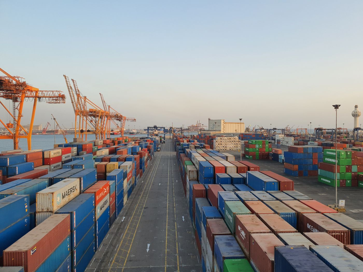 A bustling port scene with colorful cargo containers at sunrise. Ideal for logistics concepts. - King Squishy
