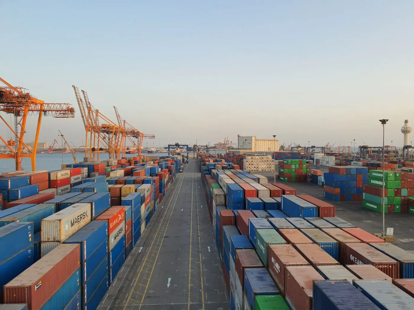 A bustling port scene with colorful cargo containers at sunrise. Ideal for logistics concepts. - King Squishy