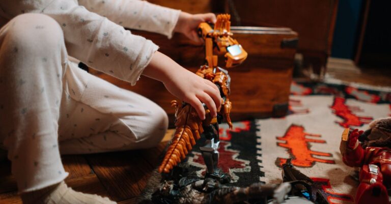 A child in pajamas plays with a toy dinosaur on a colorful rug indoors. - King Squishy