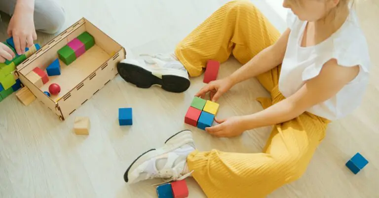 A young child playing creatively with colorful wooden blocks indoors, fostering learning and develop - King Squishy