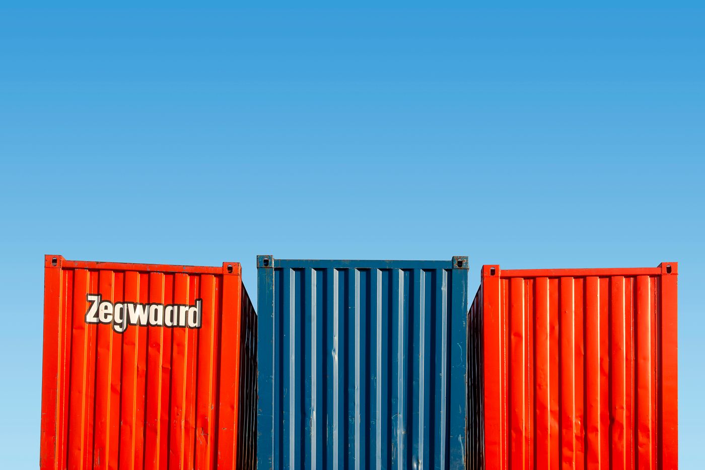 Conteneurs d'expédition colorés sous un ciel dégagé, parfaits pour des thèmes logistiques.