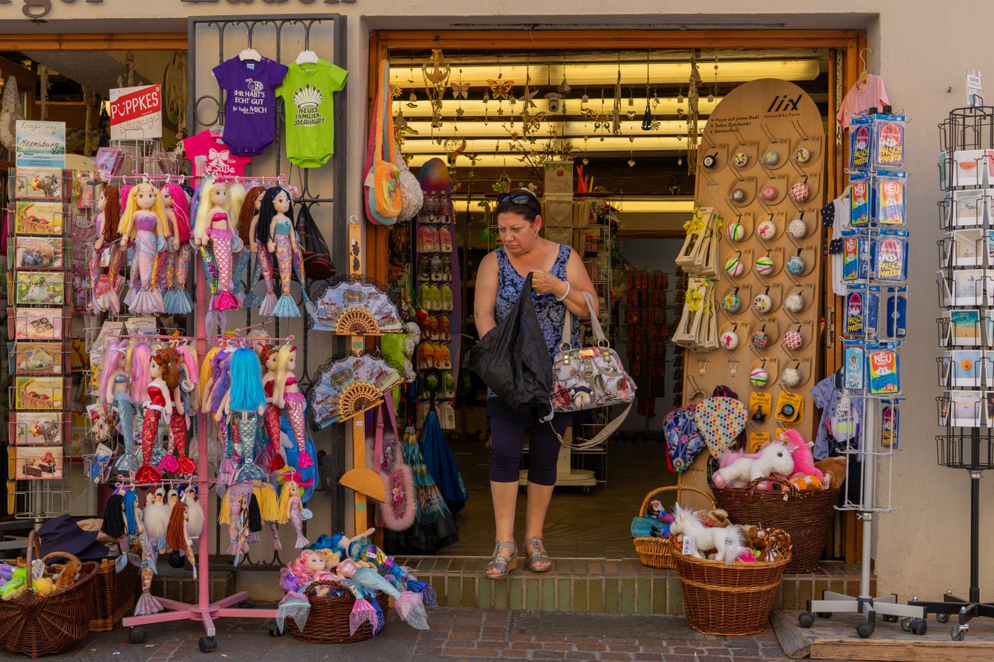 L'entrée d'une boutique de souvenirs chaleureuse remplie de jouets colorés, de poupées et de cadeaux uniques, accueillante et dynamique. - King Squishy