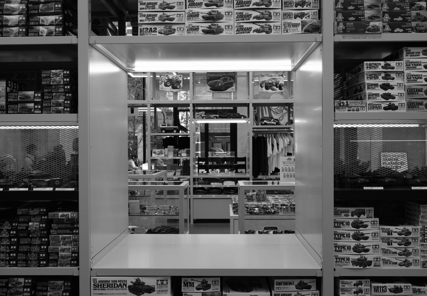 Interior view of a model kit store showing shelves filled with boxes of model kits. - King Squishy