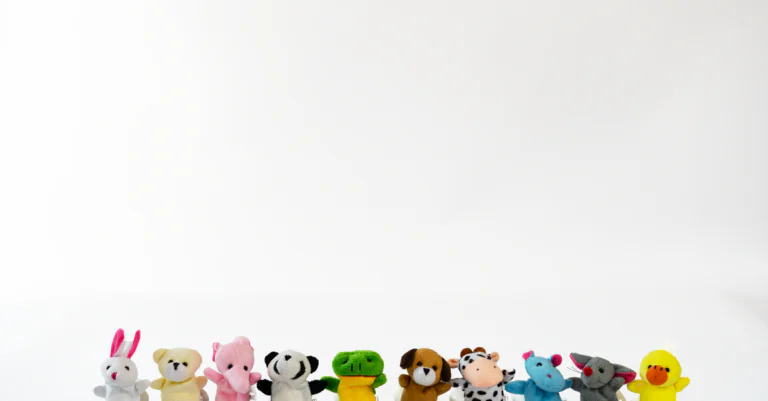 A diverse collection of colorful plush stuffed animals lined up on a white background. - King Squish - King Squishy