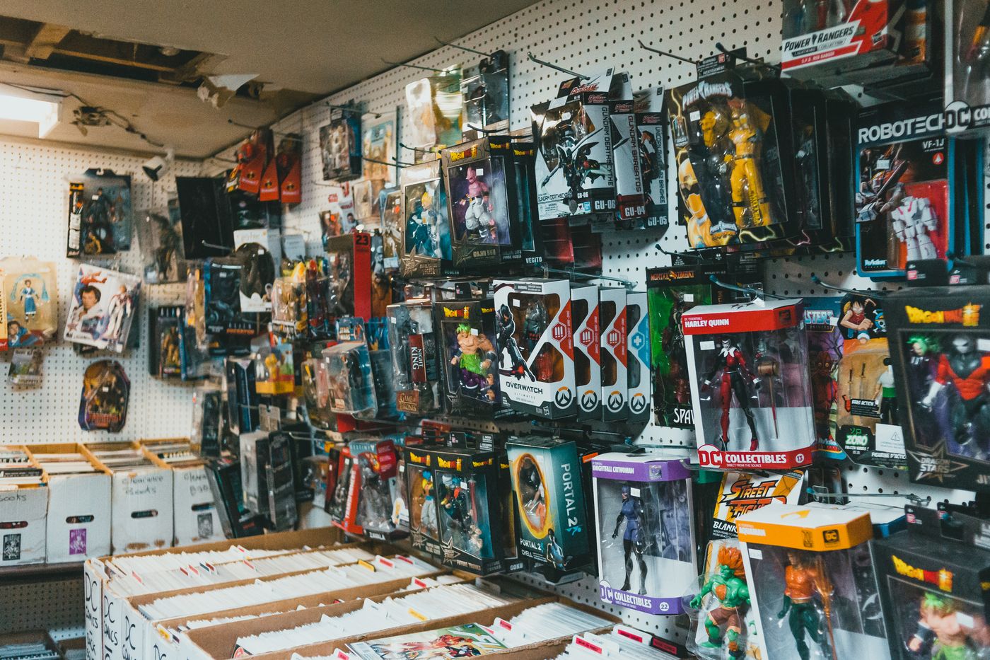 Assortiment de paquets en plastique avec des robots jouets et des super-héros suspendus à des tiges métalliques en magasin - King Squishy