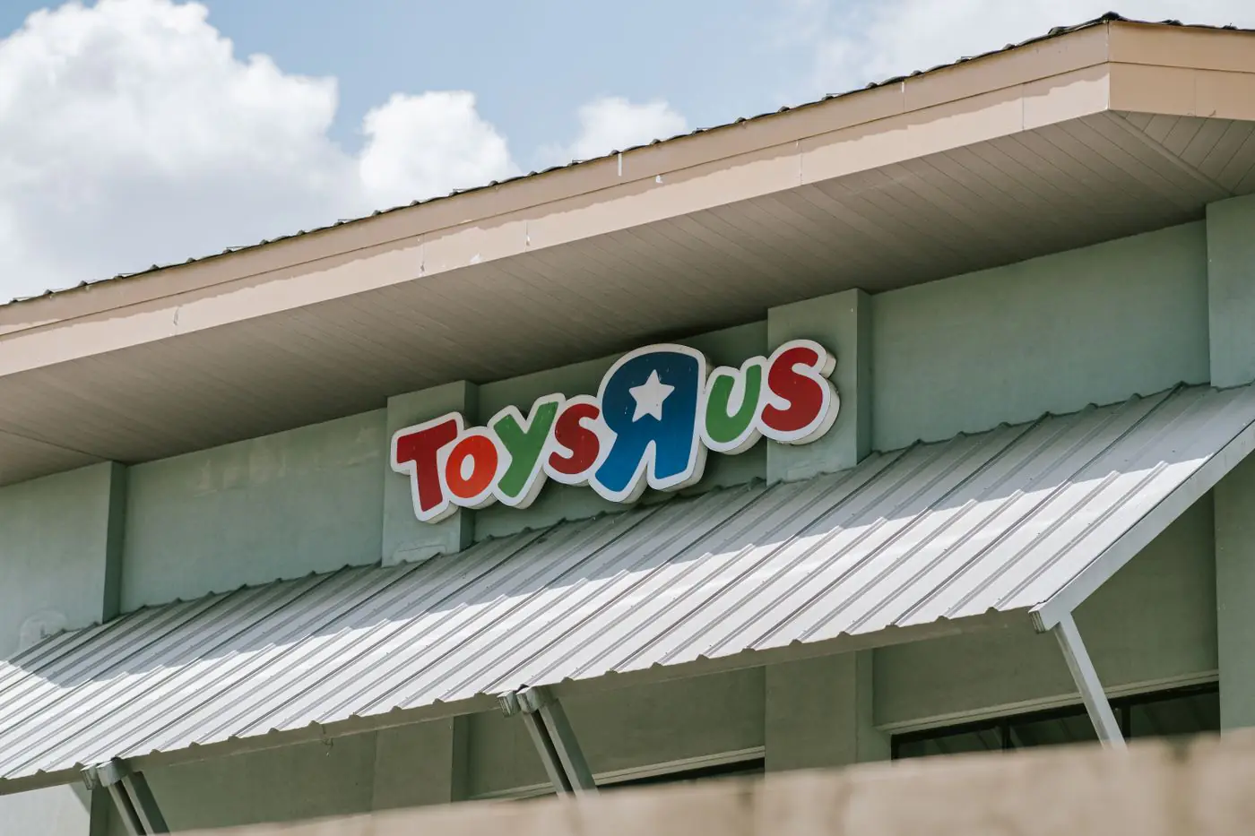 Tetto e insegna di un punto vendita Toys R Us in una giornata soleggiata con cielo azzurro. - King Squishy