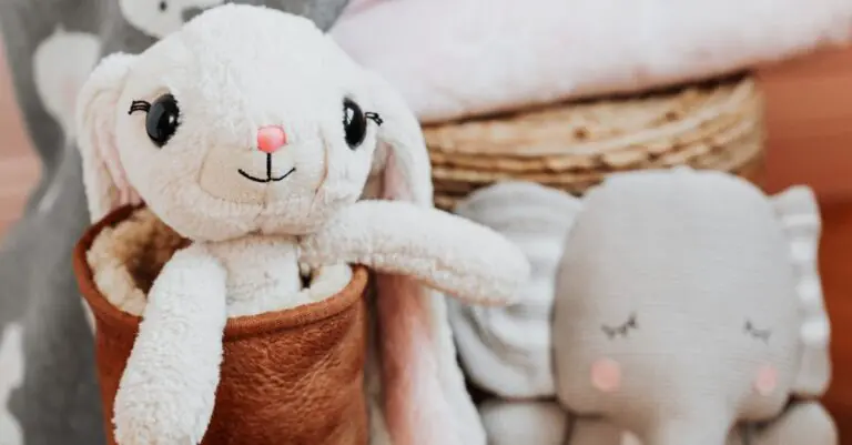 A cute plush bunny and elephant in a soft, pastel-toned nursery setting. - King Squishy - King Squishy