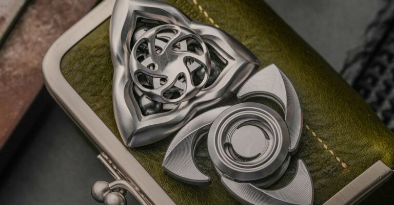 Close-up of artistic metal fidget spinners resting on a green leather wallet captures the essence of - King Squishy