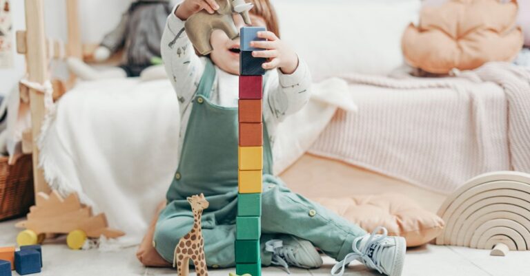 A young child engaged in creative play with colorful wooden blocks indoors. - King Squishy