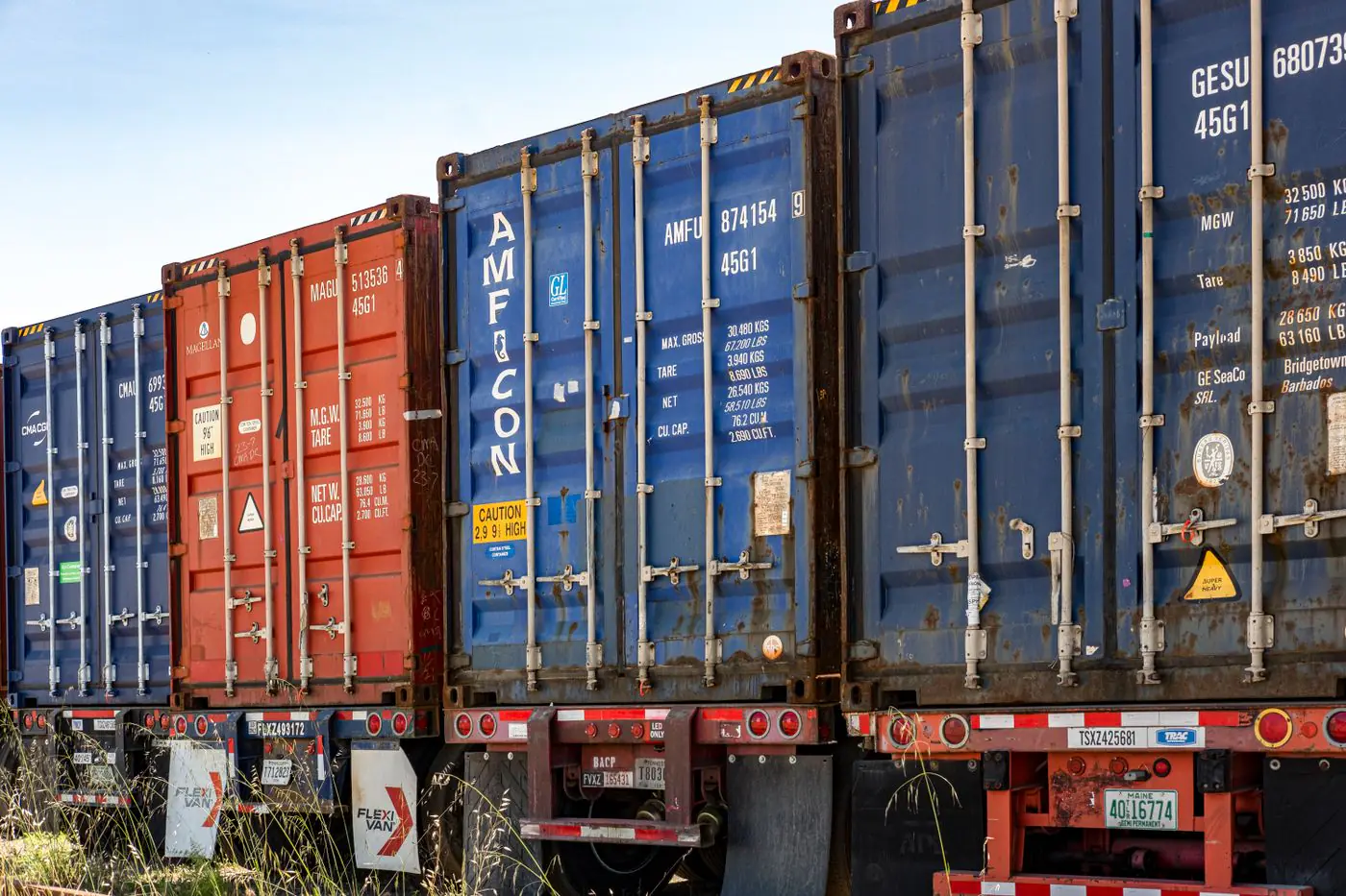 Row of colorful cargo containers in an industrial shipping yard, ready for transportation. - King Squishy