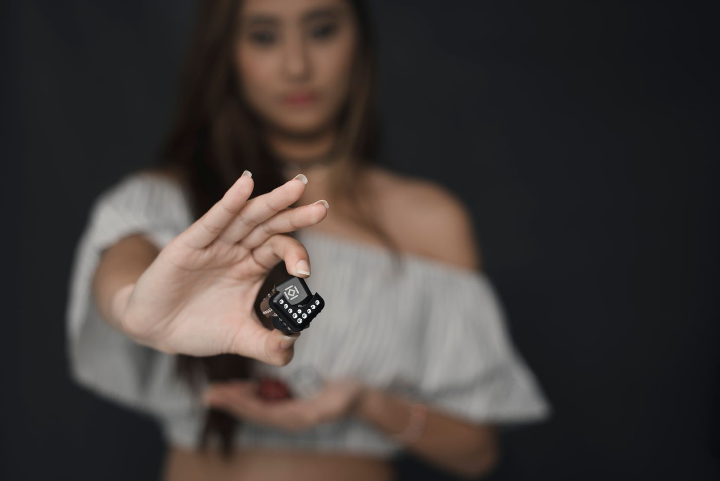 صورة لامرأة تعرض لعبة فيدجت Glitzcube في استوديو.