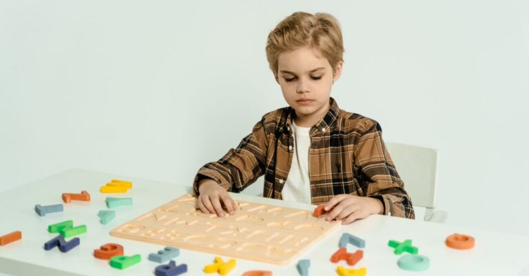 Blonde child engaging with educational alphabet toys at a table indoors. - King Squishy
