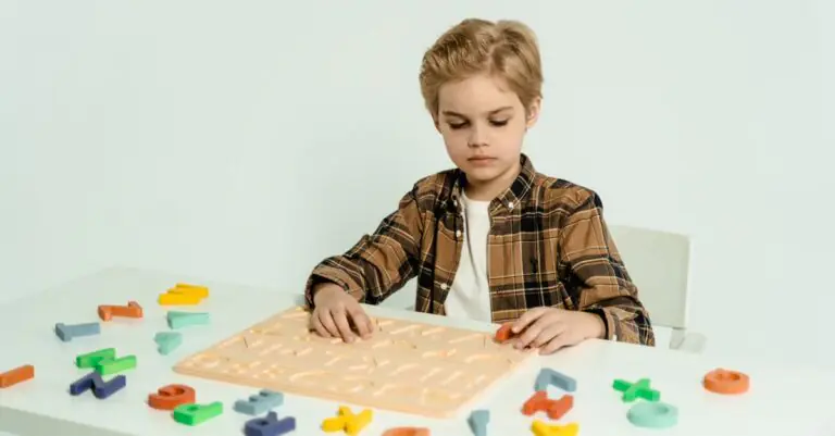 Blonde child engaging with educational alphabet toys at a table indoors. - King Squishy