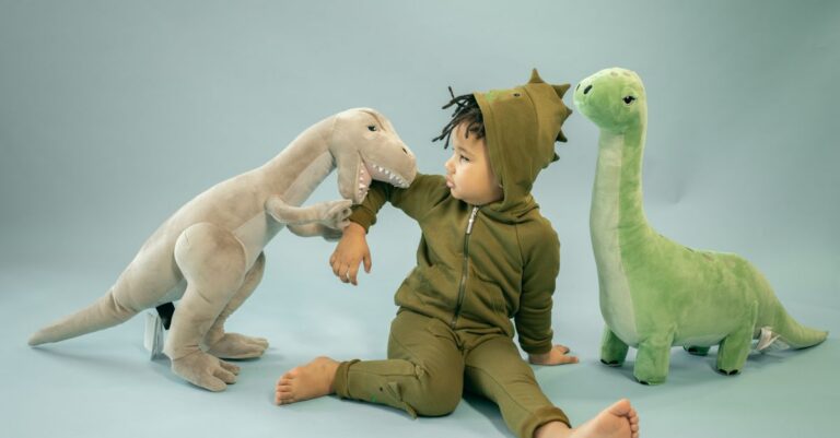Enfant afro-américain avec des dreadlocks en costume de dinosaure assis entre des peluches représentan - Ki - King Squishy