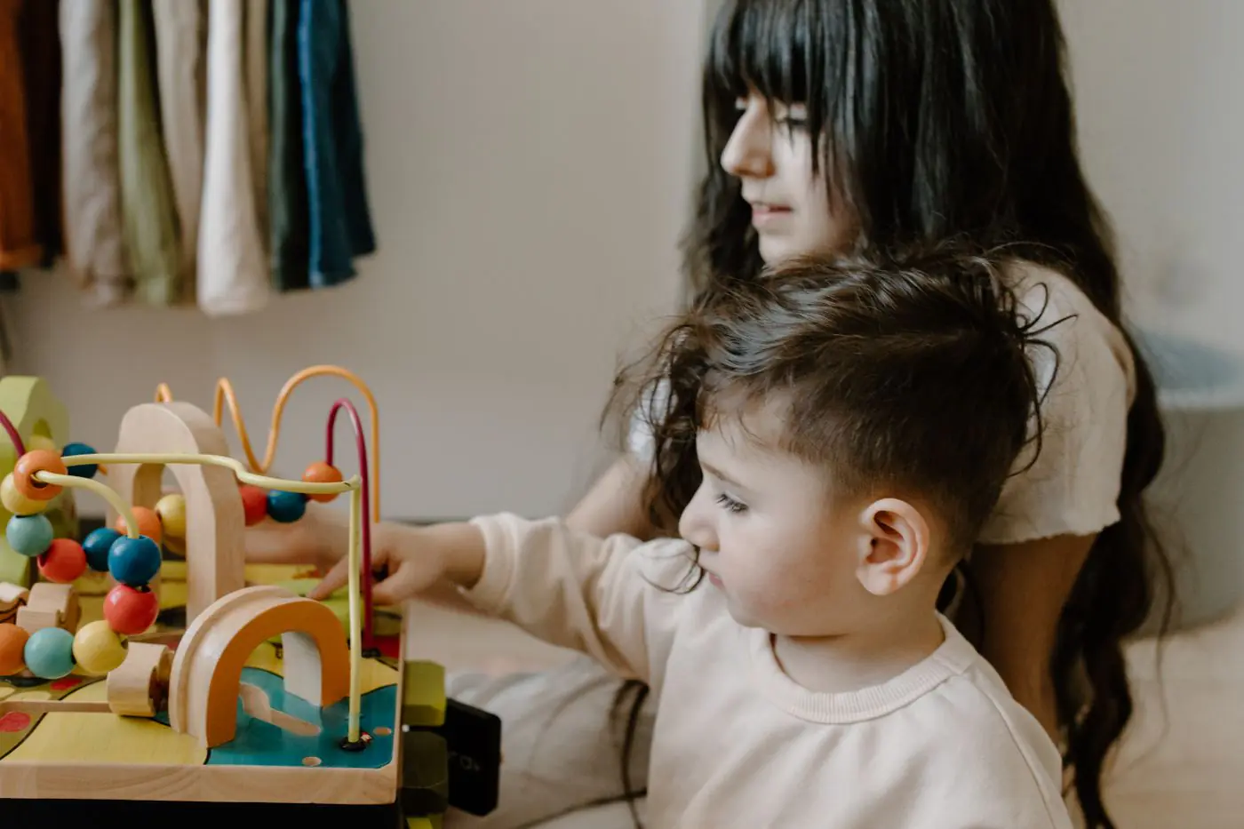 Two children engaged with wooden toys at a table, fostering imagination and playtime.
