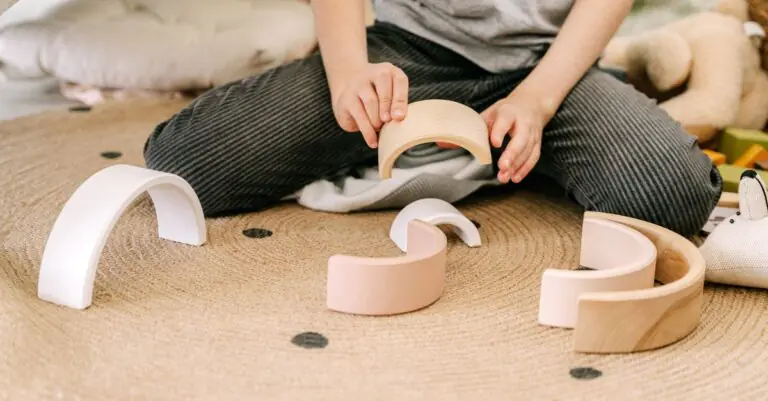 A child engaging in play with wooden arched blocks, enhancing motor skills and creativity. - King Squishy