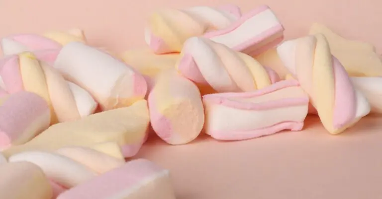 A close-up view of soft, colorful marshmallows in pastel hues. - King Squishy