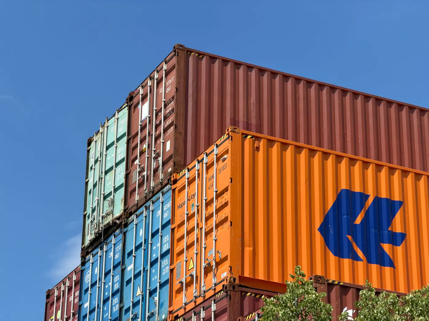 Colorful shipping containers stacked in an outdoor storage area in Germany. - King Squishy