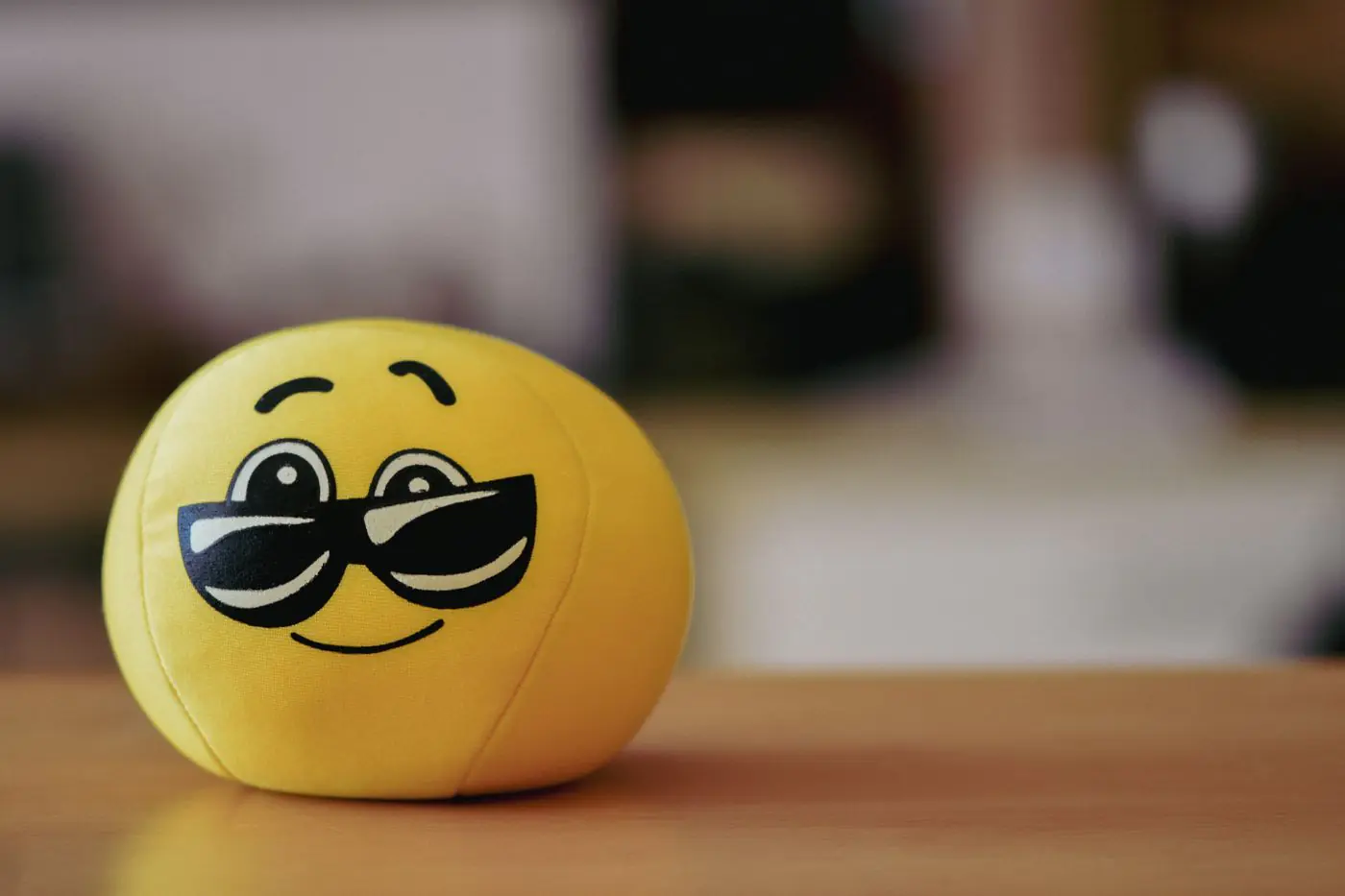 Ein fröhlicher gelber Emoji-Ball mit Sonnenbrille, perfekt für verspielte und lustige Themen. - King Squishy