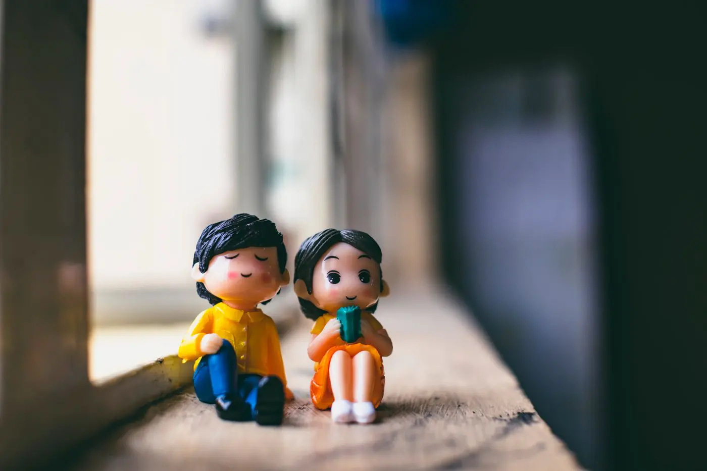 Figur pria berpakaian warna-warni di dekat pacarnya yang duduk bersandar di jendela gedung tua di hari cerah - King Squishy