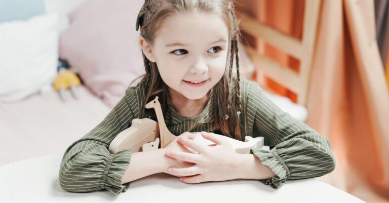 A joyful little girl with braids holds a wooden toy in a cozy indoor setting. - King Squishy