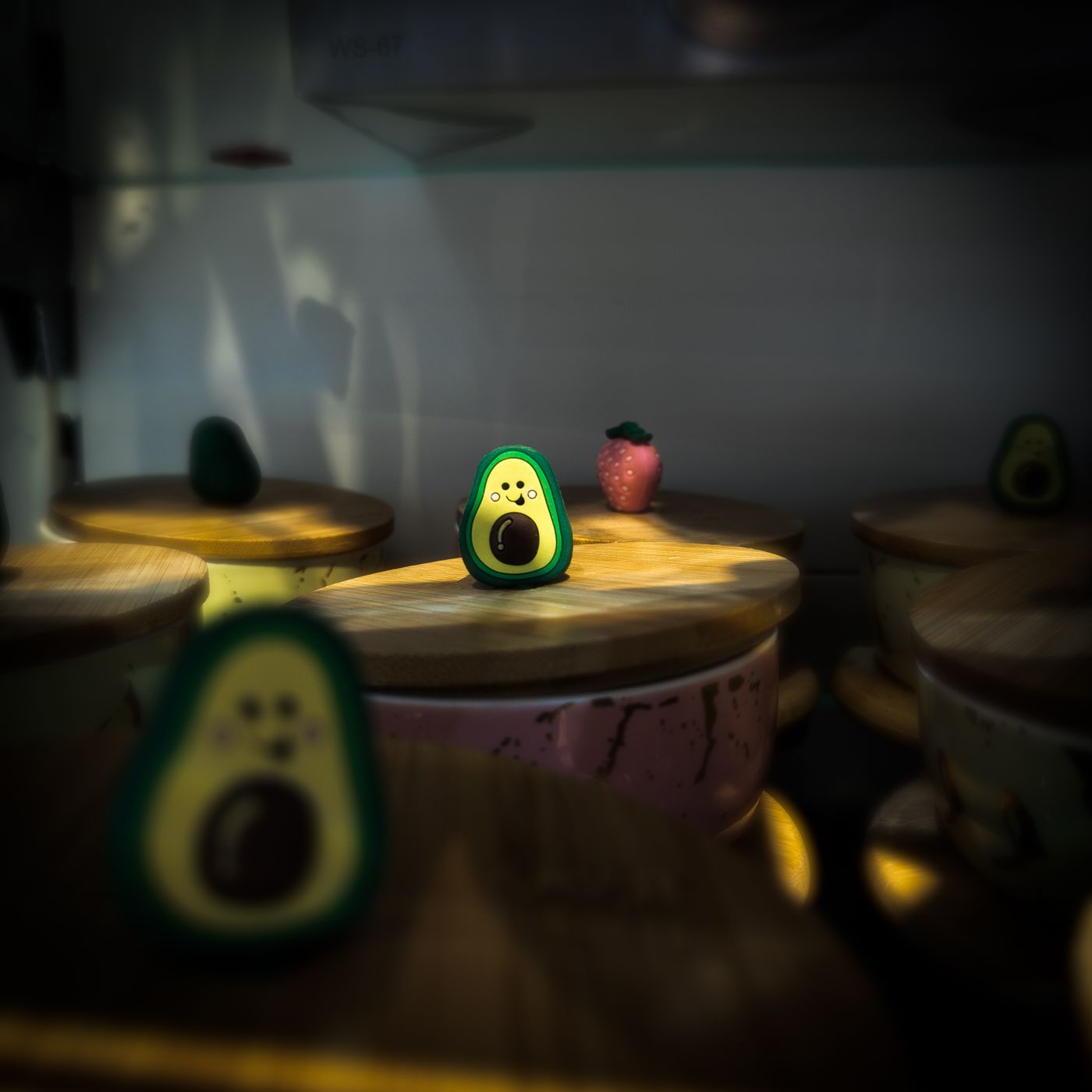Ein verspieltes Avocado-Spielzeug sitzt bei weichem Licht auf Holzdeckeln und schafft eine skurrile Ästhetik. - King Squishy